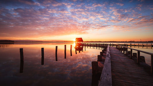 Pier over sea against sky during sunset