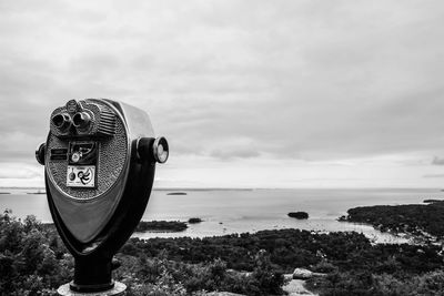 Coin-operated binoculars against sky