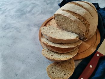 Homemade rye bread with sourdough cut into pieces lies on a wooden plank