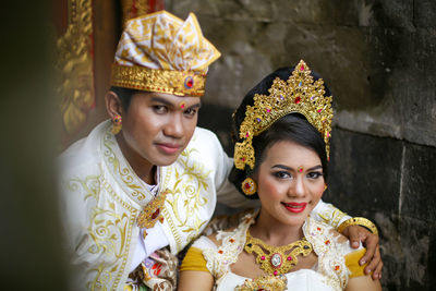 The bride and groom in traditional clothes are sitting