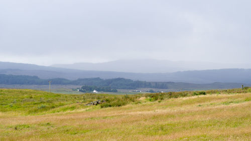 Scenic view of grassy field and mountains against sky