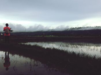 Man working at farm against sky