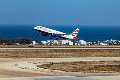 Airplane flying over sea against sky