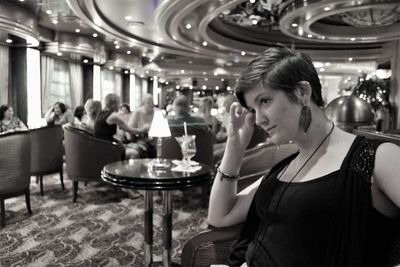 Thoughtful young woman sitting on chair in restaurant