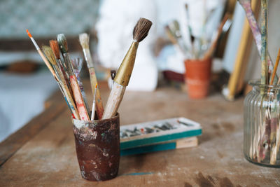 The brushes and paints on table in the art studio