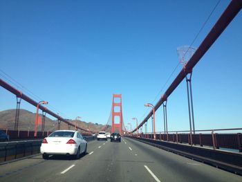 Cars on highway against clear blue sky