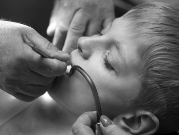 Close-up of dentist examining teeth of boy at clinic