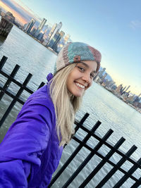 Low angle view of young woman standing against sky