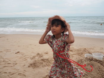 Happy girl on beach against sky