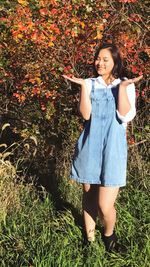 Portrait of young woman standing on grass