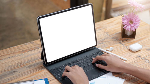 Low section of person using mobile phone on table