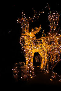 Illuminated christmas lights against sky at night