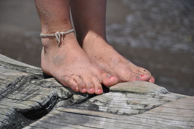 Low section of person standing on sand