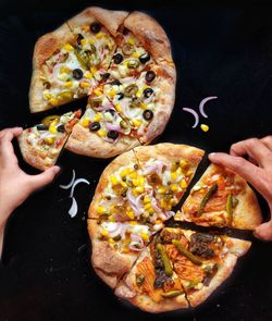 Close-up of hand holding pizza