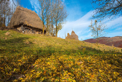 Low angle view of huts on hills against sky during autumn