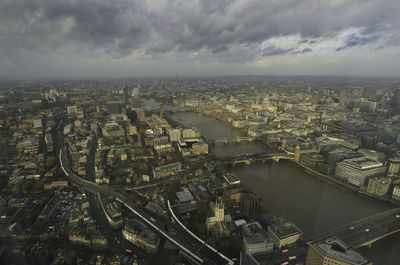 Aerial view of cityscape against cloudy sky