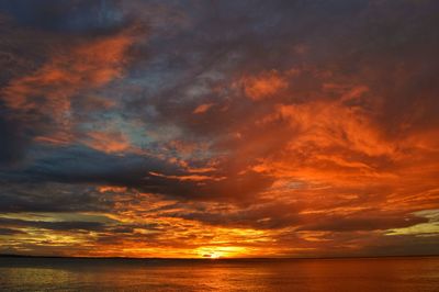 Scenic view of sea against dramatic sky during sunset