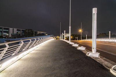 Illuminated road against sky at night