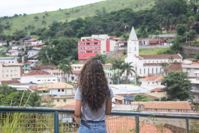 Rear view of woman standing against townscape