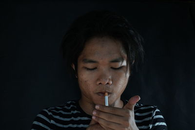 Close-up of mid adult man against black background