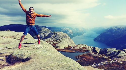 Portrait of man jumping in sea against sky