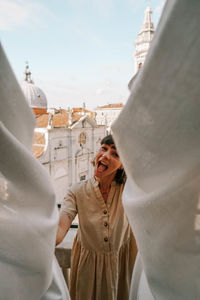 Woman standing by building in city