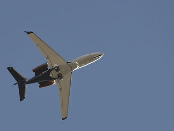 Low angle view of airplane flying in blue sky