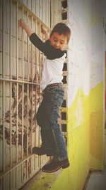 Full length of boy standing against wall