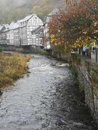 Scenic view of river by houses during autumn