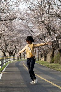 Full length of young woman walking on road