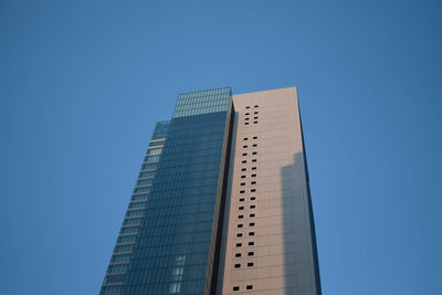 Low angle view of modern building against clear blue sky