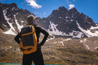 Tourist girl walking with backpacks in the mountains. hiking concept. back view of female hiker with