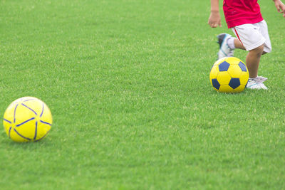 Low section of boy playing soccer on field