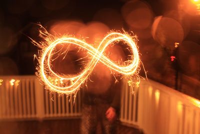 Illuminated sparklers forming infinity sign at night