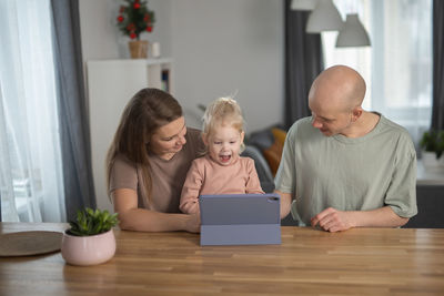Portrait of siblings using digital tablet at home