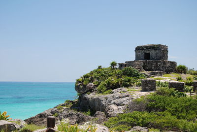 Castle by sea against clear sky