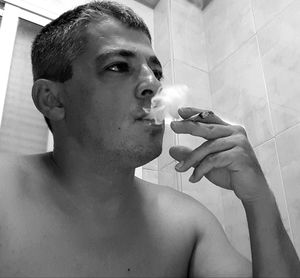 Portrait of young man smoking cigarette