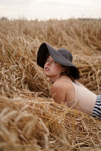 Side view of girl wearing hat on field