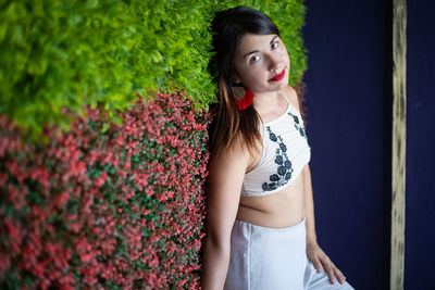 Portrait of woman standing against plants
