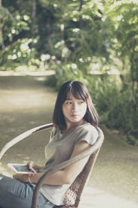 Portrait of smiling young woman sitting outdoors