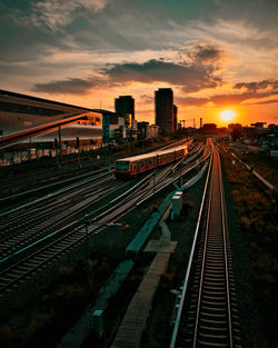 Railroad tracks against sky during sunset