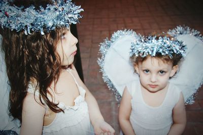 Cute girls wearing fairy costumes standing on footpath