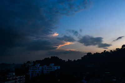Silhouette city against sky at sunset