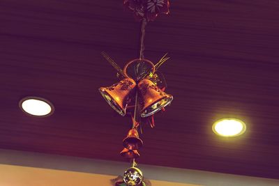 Low angle view of illuminated lighting equipment hanging on ceiling