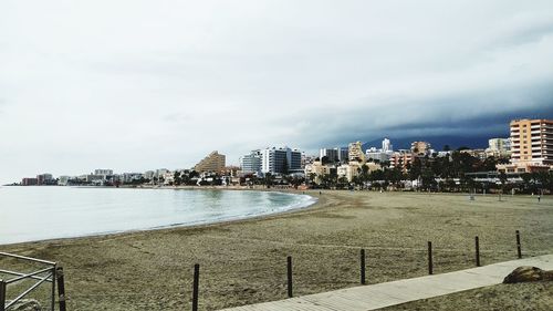 Buildings by sea against sky