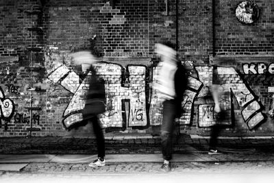 Blurred motion of people walking on wall in city
