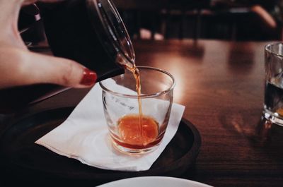 Midsection of man pouring coffee in glass