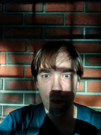 Portrait of young man against wall