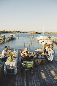 High angle view of woman sitting with friends playing guitar in party at harbor