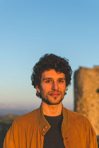 Portrait of smiling man standing against clear sky